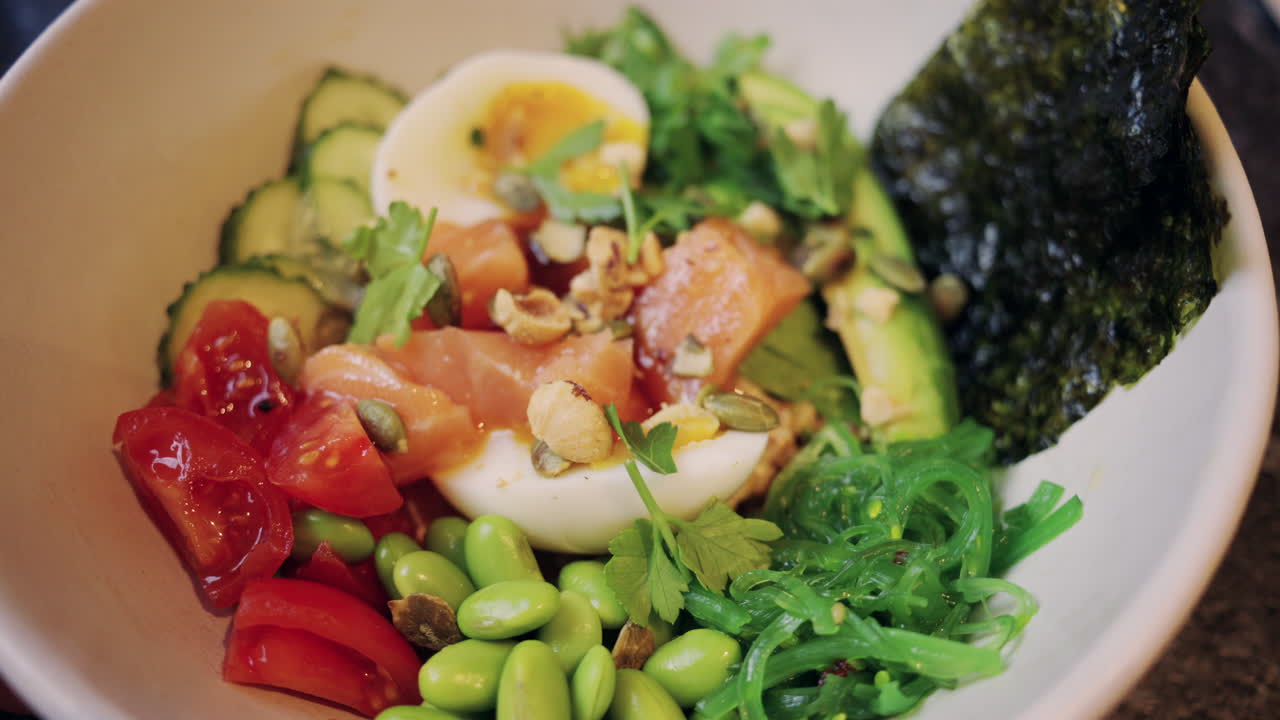 Salad salmon sehat dengan telur rebus setengah matang, alpukat, dan sayuran segar.