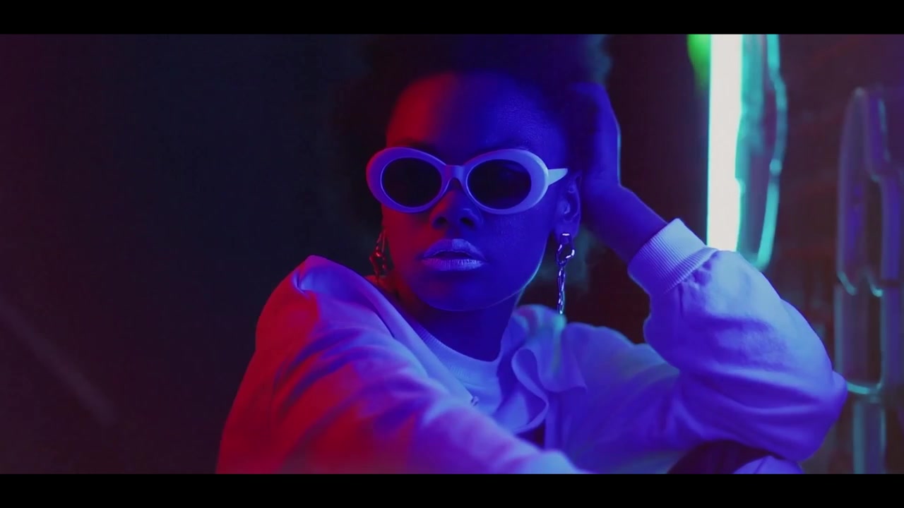 Giovani alla moda in illuminazione al neon futuristica con effetti di sovrapposizione di vetro rotto