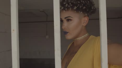 afro american woman in yellow dress walking behind the bars of a jail