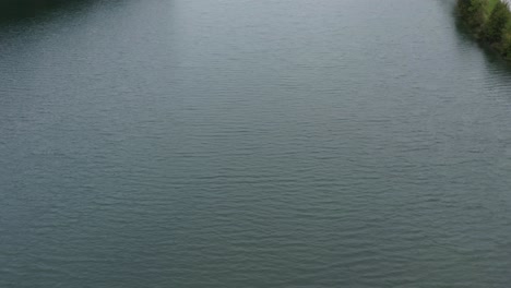 Freibach-reservoir-dam-in-the-south-Austrian-Alps-on-a-calm-day,-Aerial-tilt-up-reveal-shot