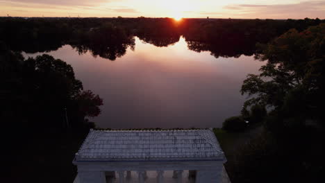 drone flies over the temple to music to a sunset over the lakes in roger williams park