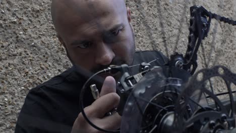 Shallow-Focus-On-Adult-UK-Asian-Male-Checking-Derailleur-On-Bike