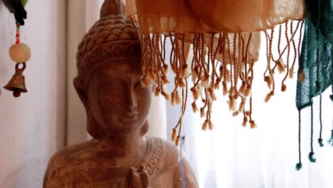 A-Spiritual-Moment:-Woman-Reading-a-Red-Book-in-Front-of-Colorful-Scarf-Adorned-Buddha-Statue