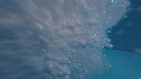 agua burbujeante debajo de la superficie de la piscina - tiro bajo el agua