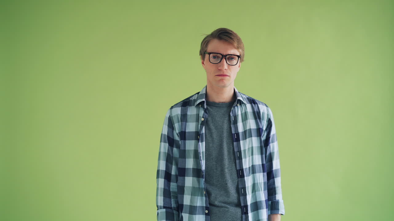 Man with glasses and plaid shirt, expressing disapproval