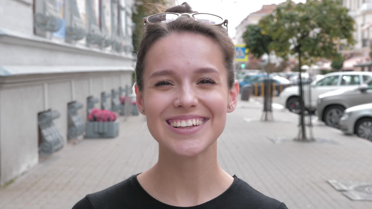una joven sonriente en la calle.