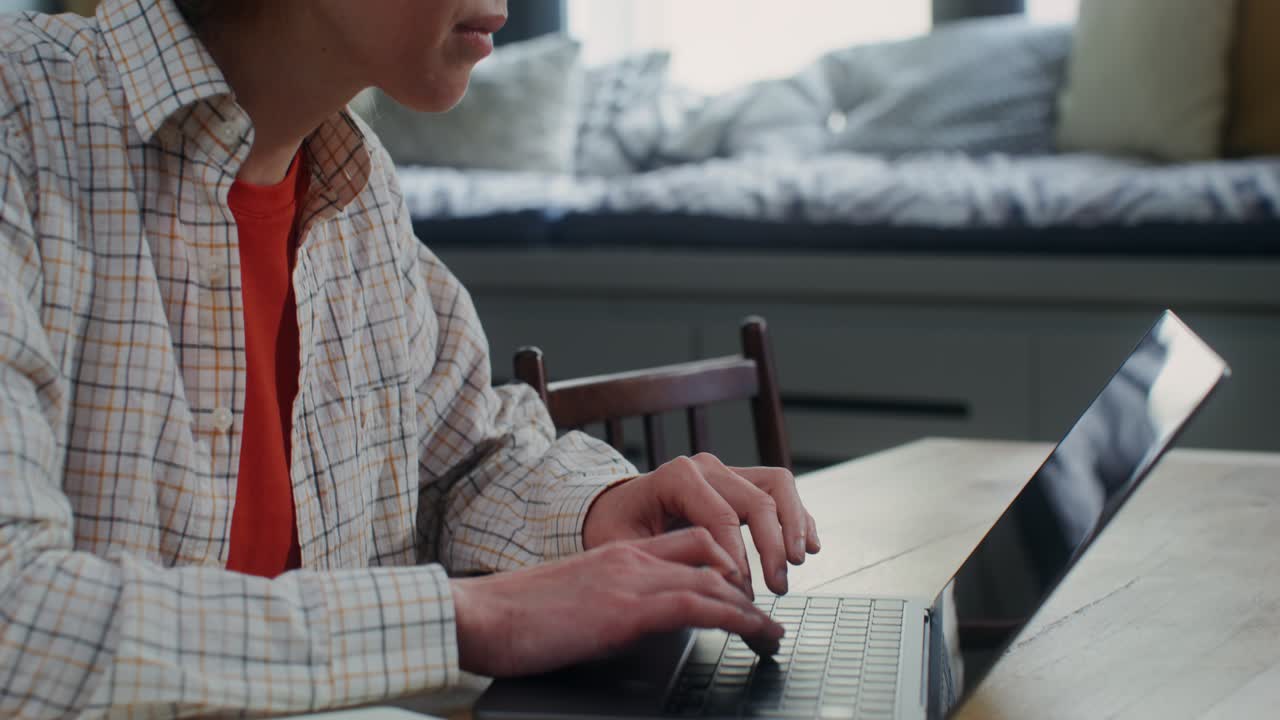 persona que trabaja en una computadora portátil en casa