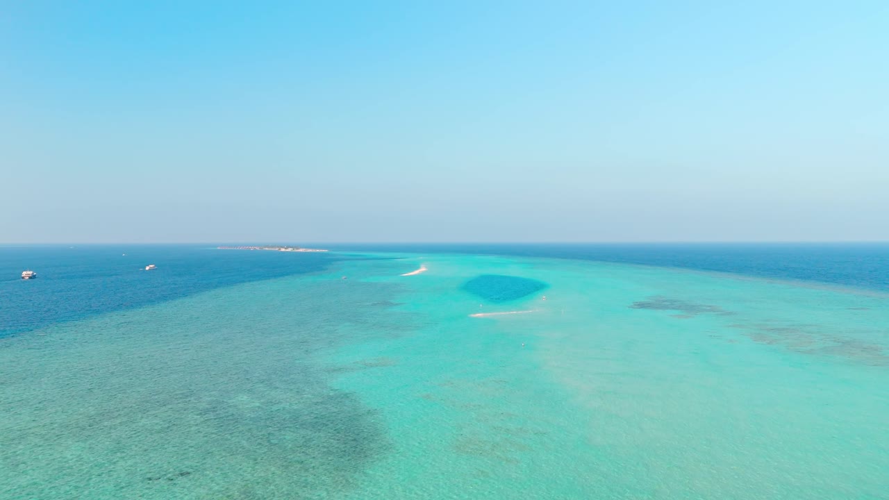 An awe-inspiring aerial drone view captures the Rasdhoo Sandbanks glowing under the soft, golden light of sunset in the Maldives.