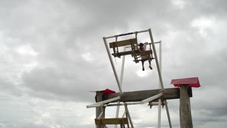 estilo de vida rural de los niños divertidos en el norte de tailandia, enorme columpio de madera hecho a mano