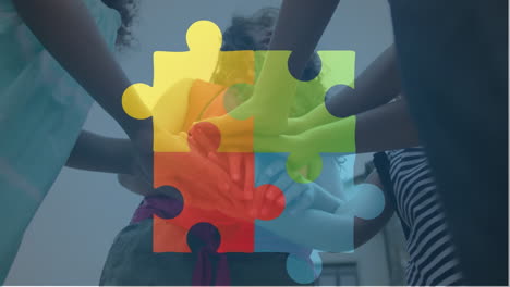 animation of connected puzzle pieces over low angle view of diverse children putting hands together