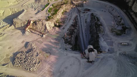 heavy-duty dump truck dumps the stones in a crusher house in quarry - mining operations and material processing. thornton illinois quarry