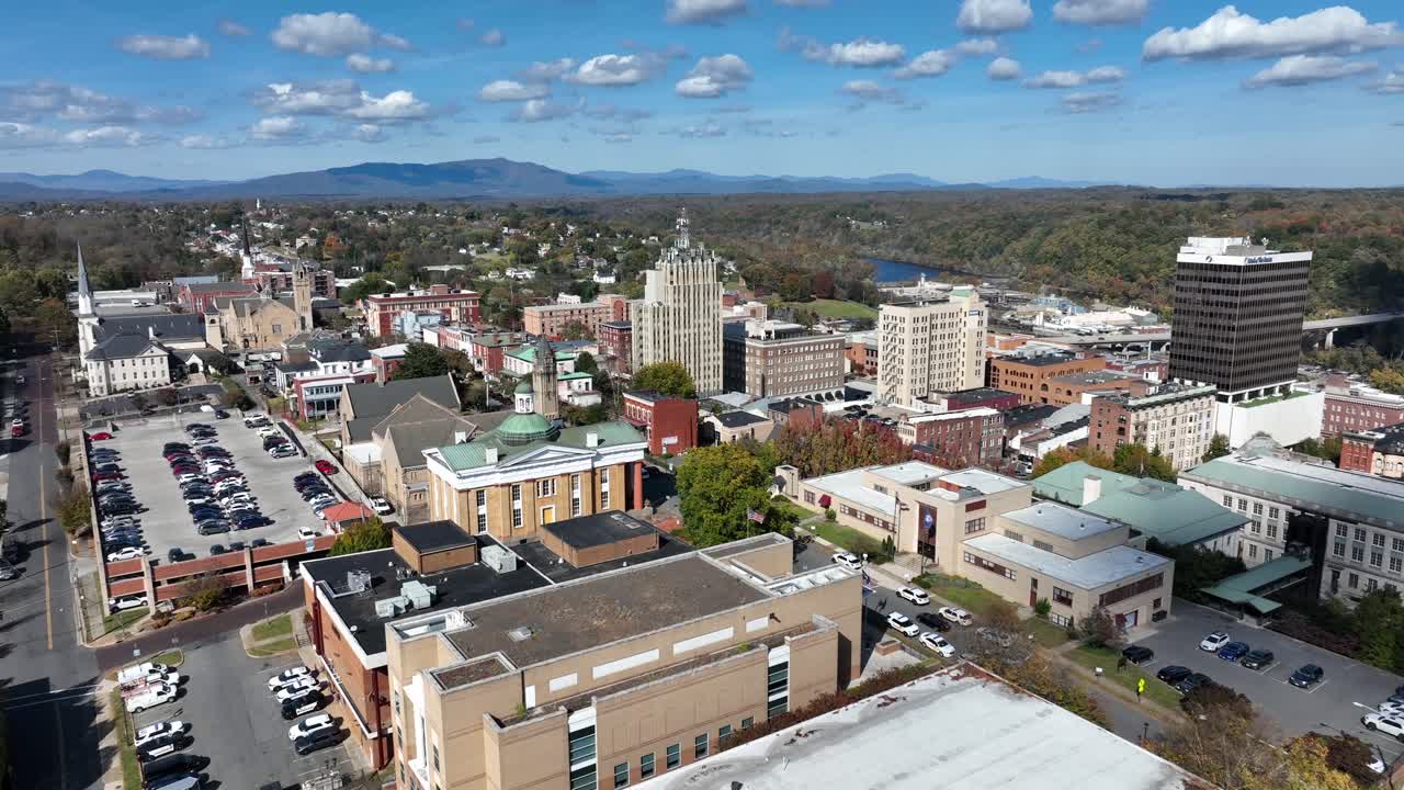 Downtown of Lynchburg City during sunny day in fall. Parking cars in American town with high-rise buildings. Aerial approaching shot. Virginia state , USA. Wide shot.