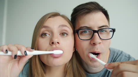 couple brushing teeth together