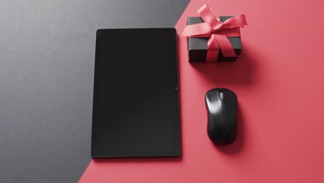 video of tablet with blank screen, box and computer mouse on red and black background