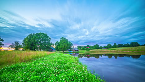 timelapse of small pond and house with beautiful clouds whisping by