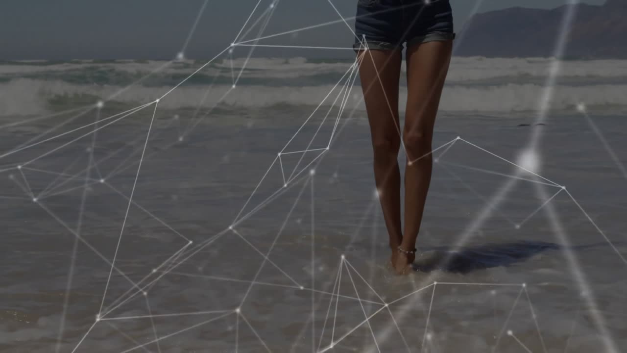 Wanita menggeser berat badan di tepi pantai, melangkah mundur ke dalam buih menciptakan overlay teknologi air berputar.