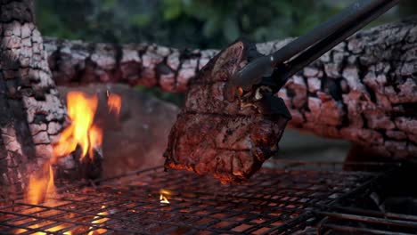 filete de chuletón de primera calidad asado a la parrilla en un fuego de leña y manipulado con pinzas