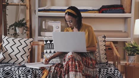 diseñadora femenina usando una computadora portátil y dibujando en el estudio