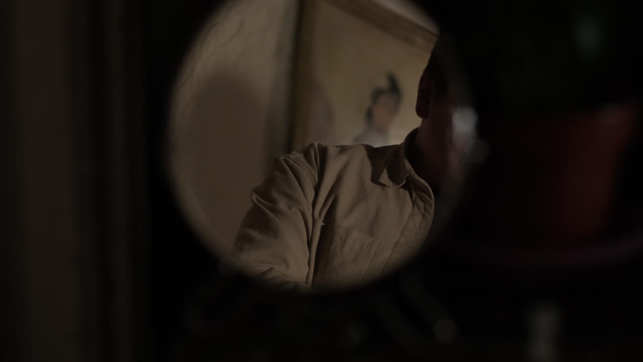 Reflection in the mirror of a young guy looking bottom