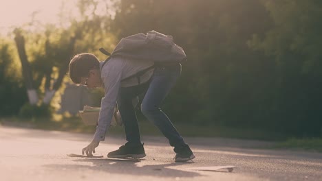 young guy with bag and in glasses gathers books and sheets