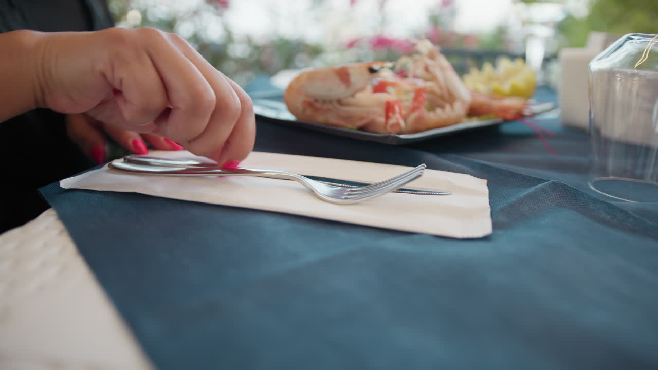 At The Beach Restaurant A Woman Removing Fork And Knife From The Paper Box