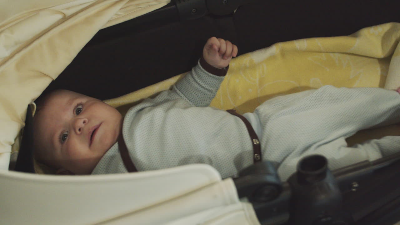 A four months old baby cries in the baby carriage