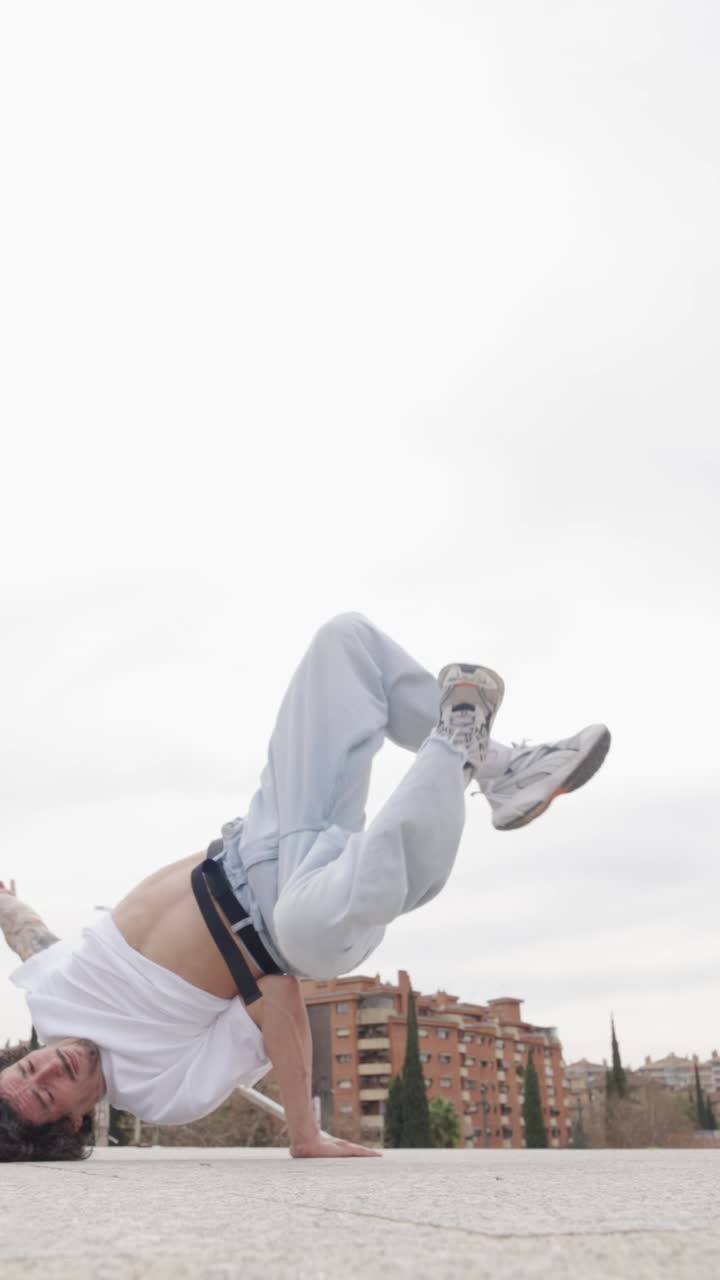 Breakdancer performing handstand and freeze in urban environment