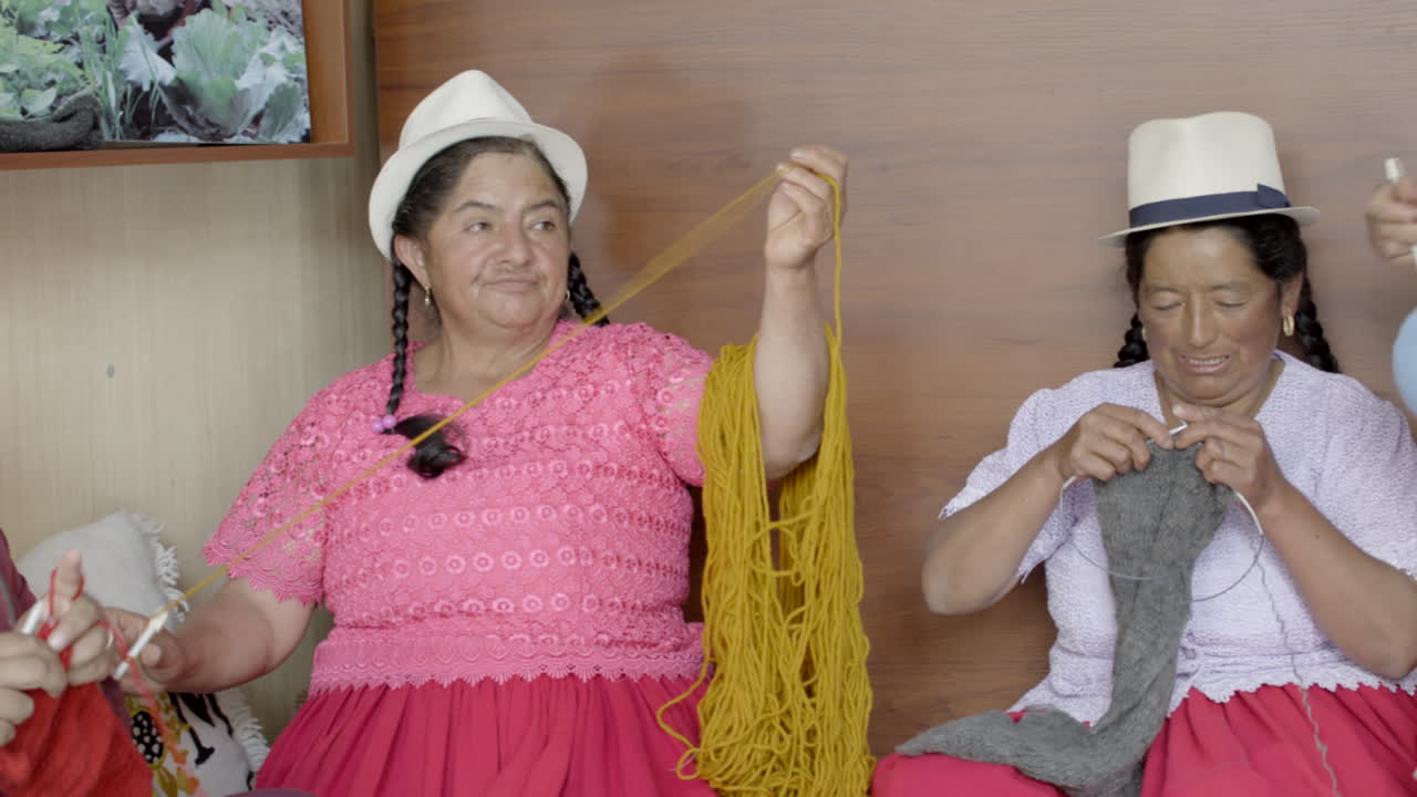group of indigenous women working with wool thread