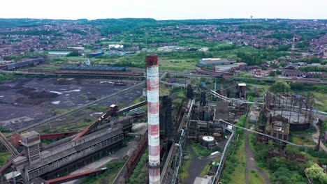 Aerial-view-of-abandoned-steel-factory-with-urban-background