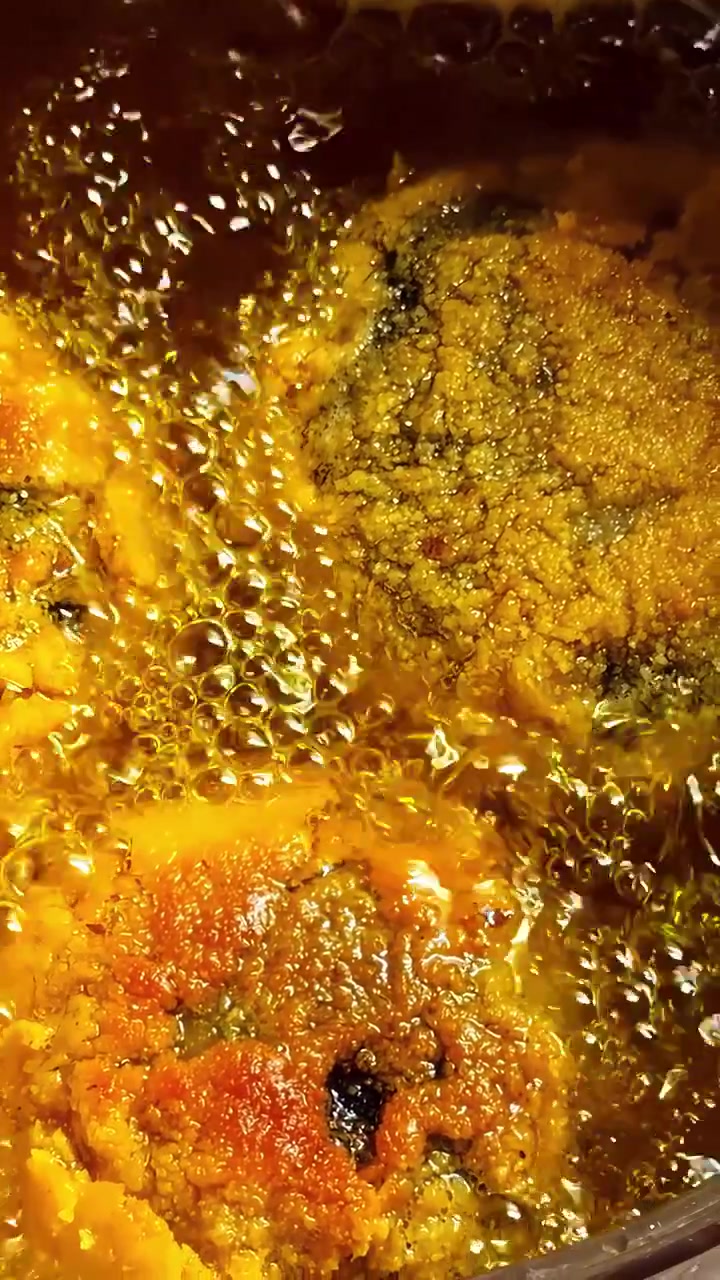 Extreme close up of golden breaded meat or vegetable cutlets sizzling in hot bubbling oil. Perfect for culinary documentaries, cooking tutorials, and food industry content.