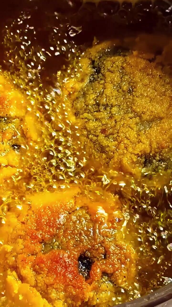 Extreme close up of golden breaded meat or vegetable cutlets sizzling in hot bubbling oil. Perfect for culinary documentaries, cooking tutorials, and food industry content.