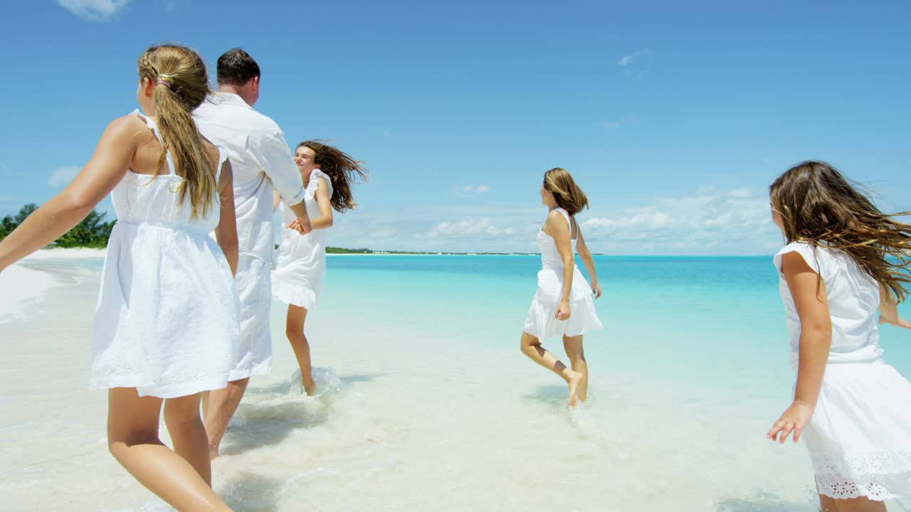 Caucasian parents and their female children enjoying beach