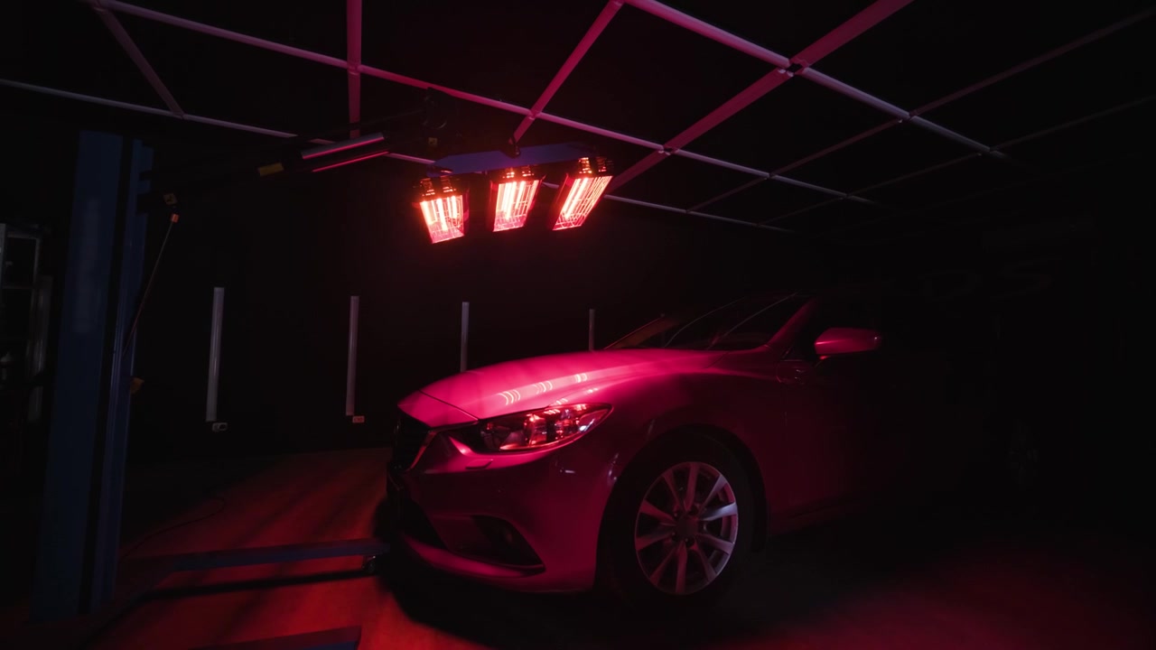 Red lamps for drying the ceramic coating are behind car