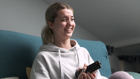 young woman enjoying a joyful moment while laughing at a television show