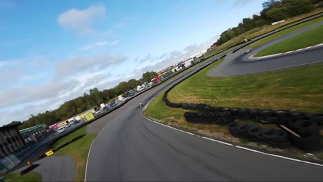 Karting-Pasando-La-Línea-De-Meta-Mientras-Es-Perseguido-Por-Un-Dron-Fpv