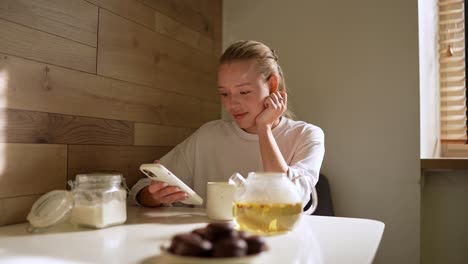 woman using smartphone in a kitchen setting