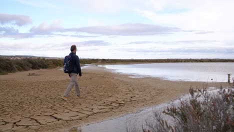 slow motion revealing shot of a man walking along the edges of the sete salt flats