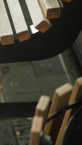 primer plano de una bicicleta sucia que se mueve en su lugar entre un banco de madera y una estructura cercana en un parque pacífico, el ciclista deja que la bicicleta descanse en el banco mientras se sienta en el banco