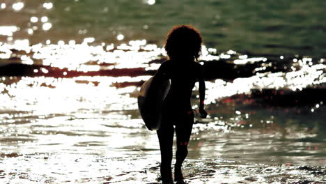 silhouette of woman walking out the sea