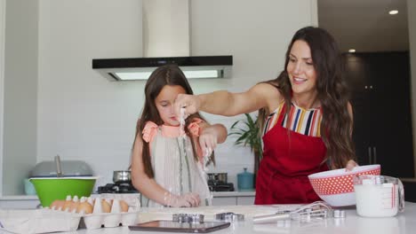 madre y hija caucásicas felices horneando juntas en la cocina