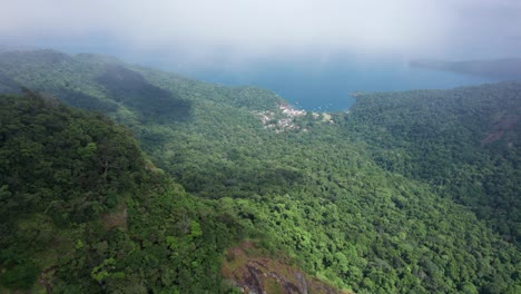 la antena tropical desciende a través de las nubes para revelar la bahía de abraao en brasil