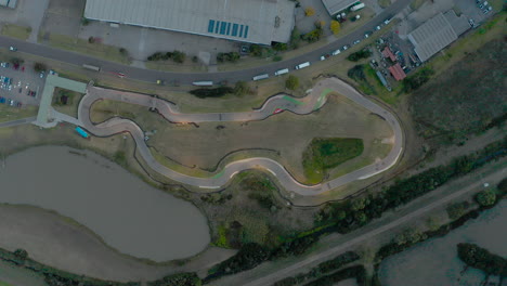 perspectiva estática de drones de karts conduciendo alrededor de la pista de karts durante la luz del atardecer