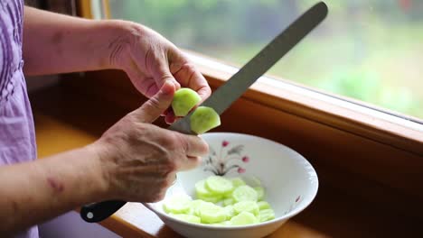 peel and cut cucumber with knife with wrinkled hands-1