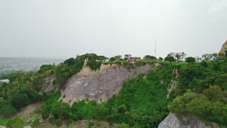dron volando hacia colinas con árboles
