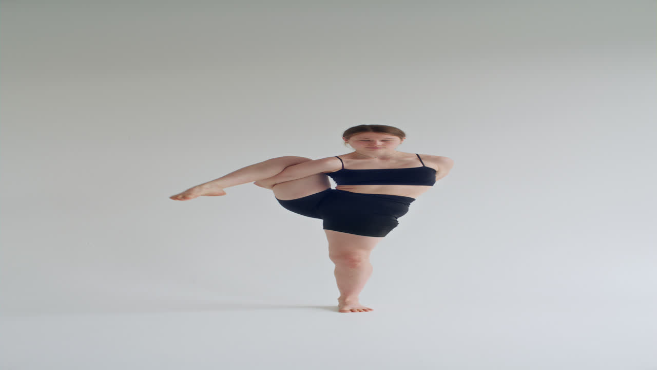 Young Woman Holding Standing Compass Pose during Yoga Practice