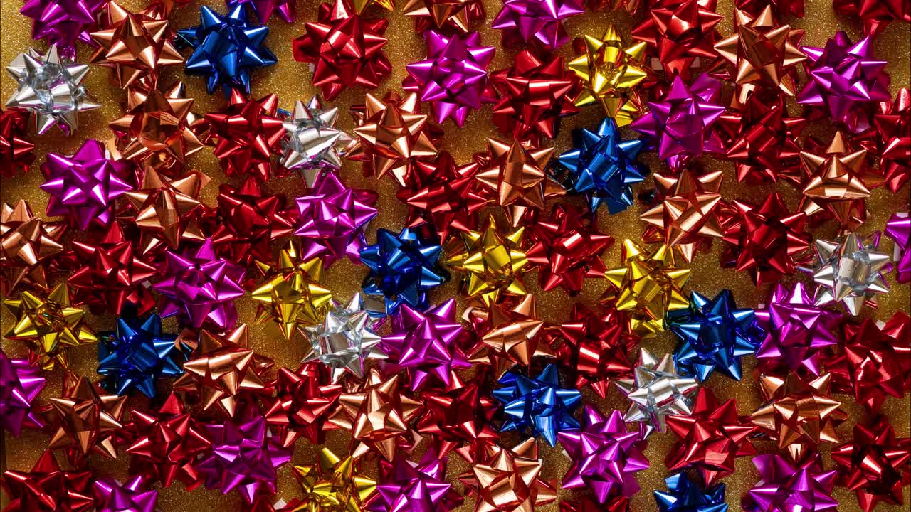 크리스마스 스 모션으로 크리스마스라는 단어를 천천히 입력 하 대문자로 다채로운 활으로 가득 찬 배경에