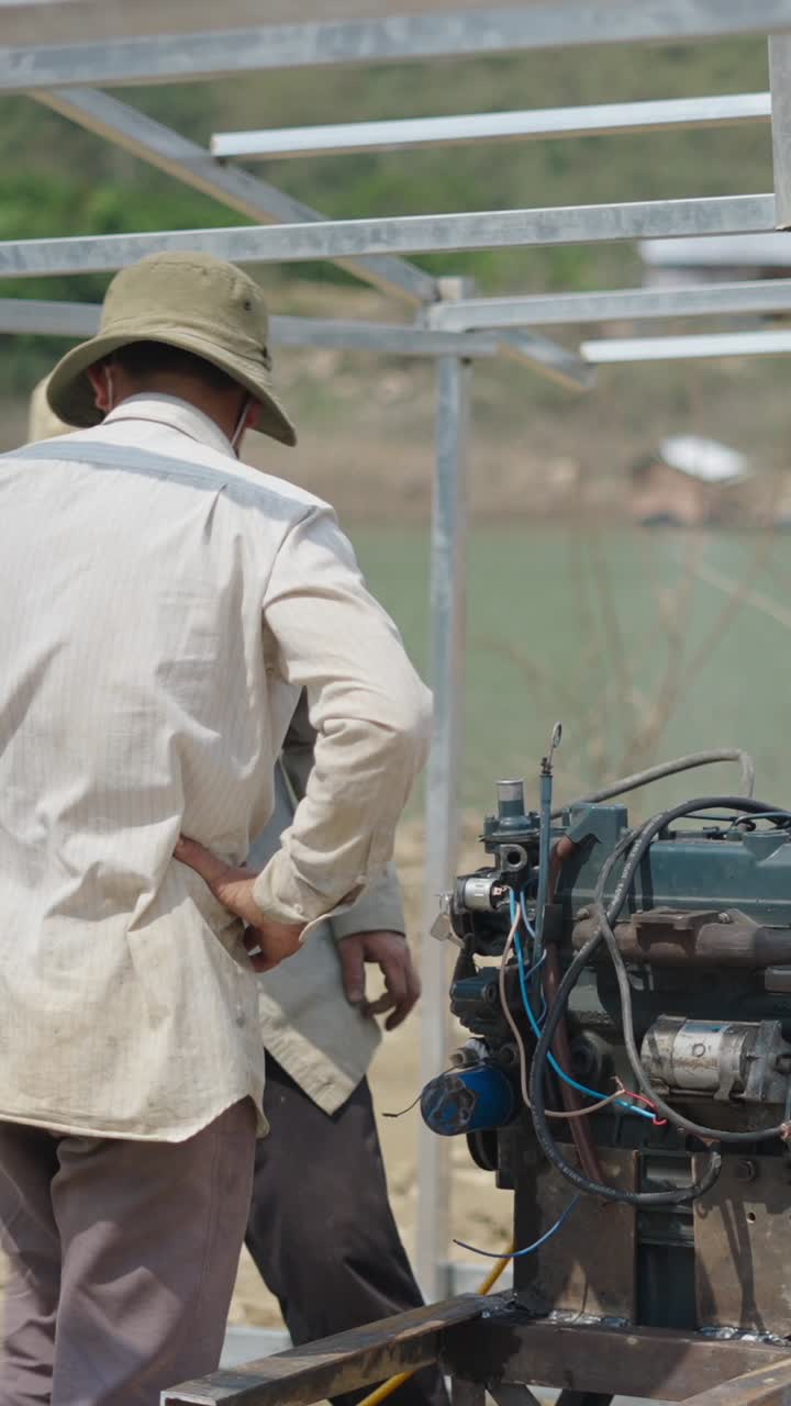 Men repairing an engine outdoors