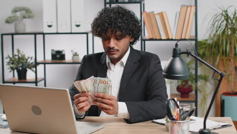 rich businessman in suit working on laptop pc counting money cash calculate earnings income profit