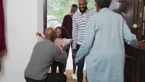 Video-of-happy-african-american-parents-and-daughter-arriving-at-house-of-her-grandparents