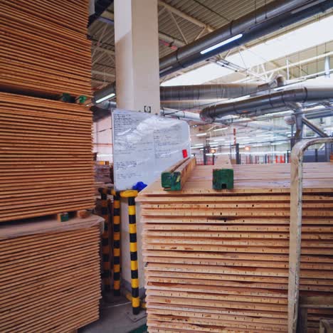 interior of factory for wooden production. wooden boards for floor parquet inside the huge industrial plant. piles of plywood in the manufacturing.
